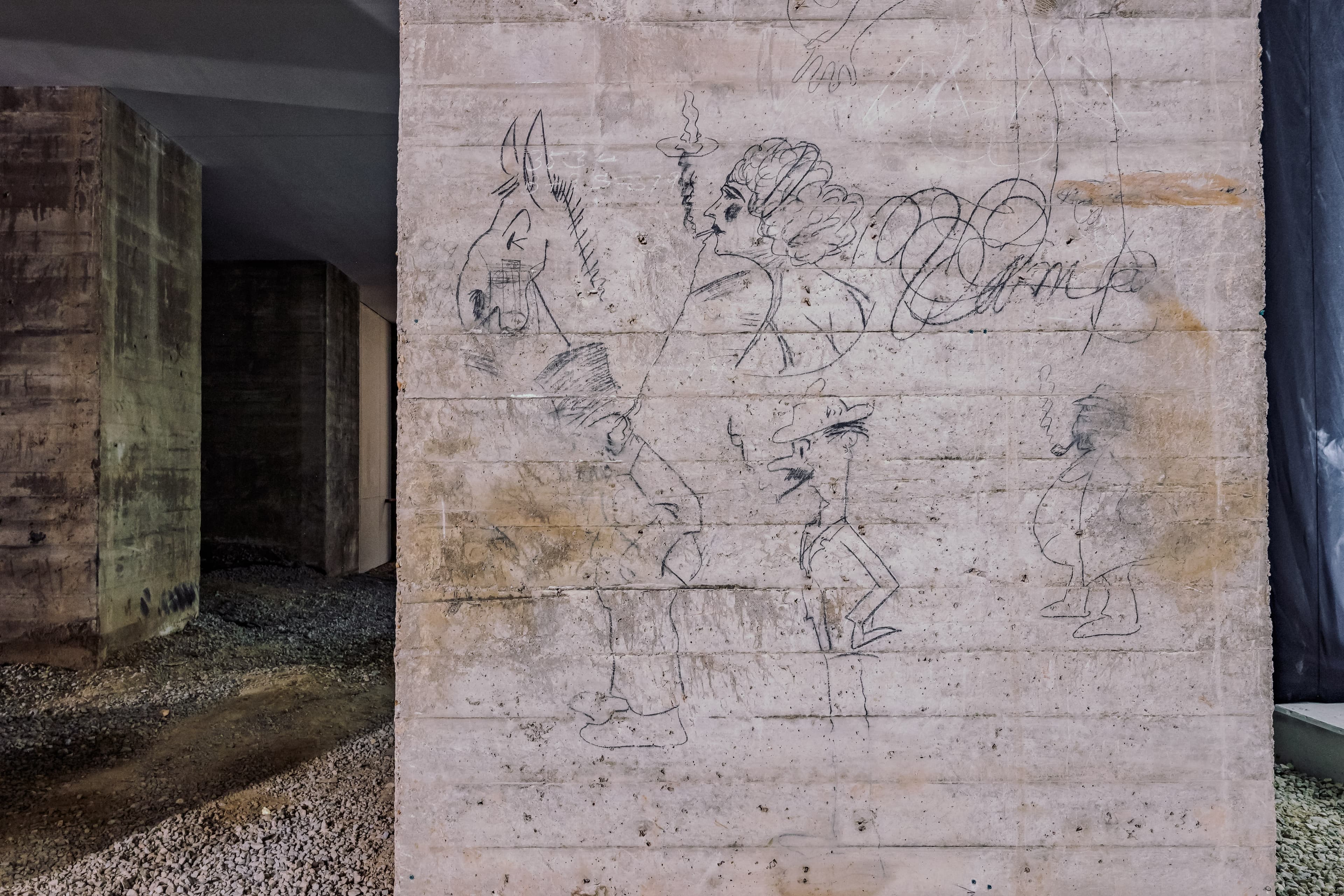 A close shot of the graffiti in publicly inaccessible areas of the Undercroft. On one of the memorial pillars, there is graffiti of caricatures of donkeys, a businessman, and a drawing of a woman.