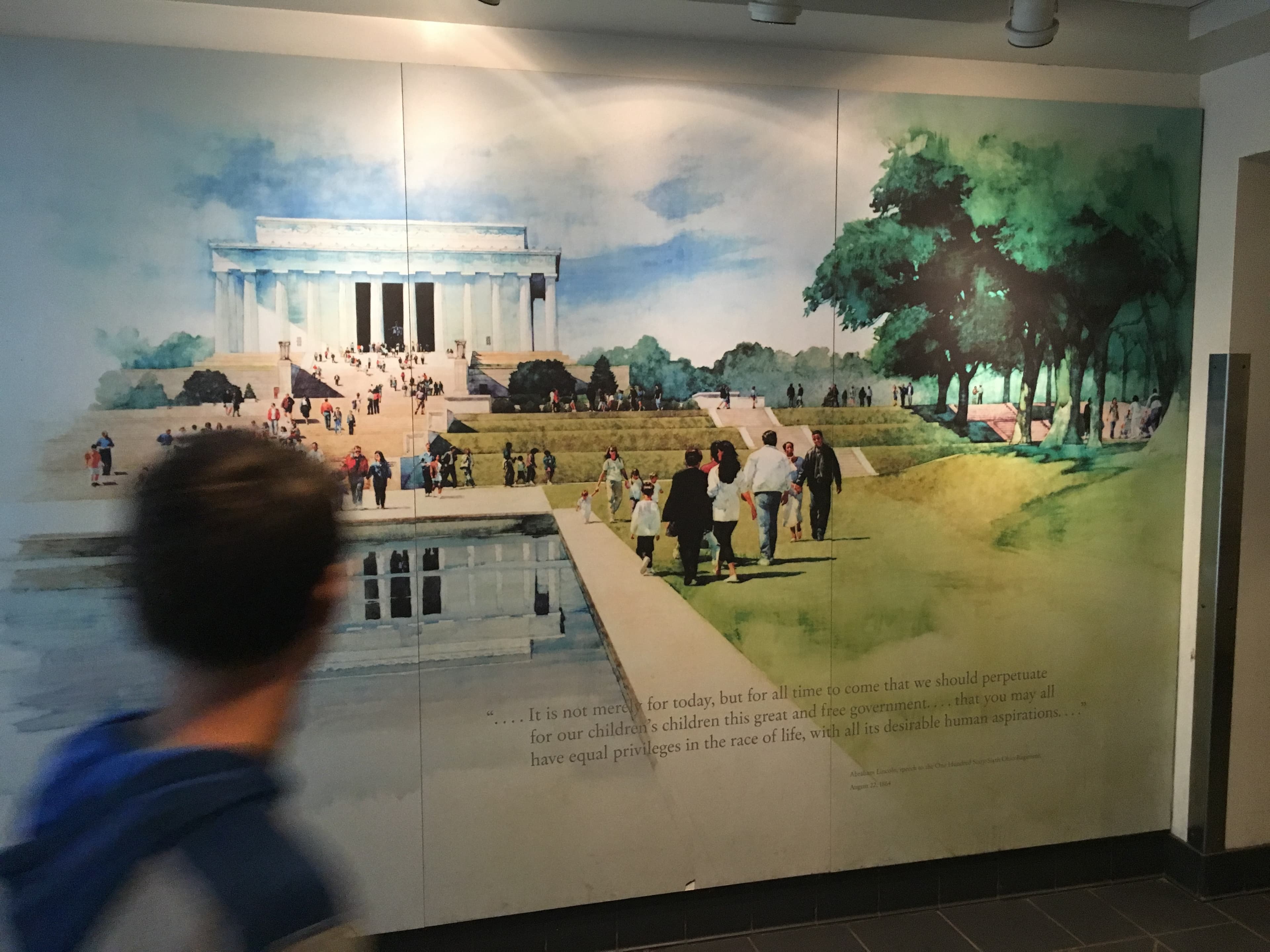A child is looking a painting of a the Lincoln Memorial 