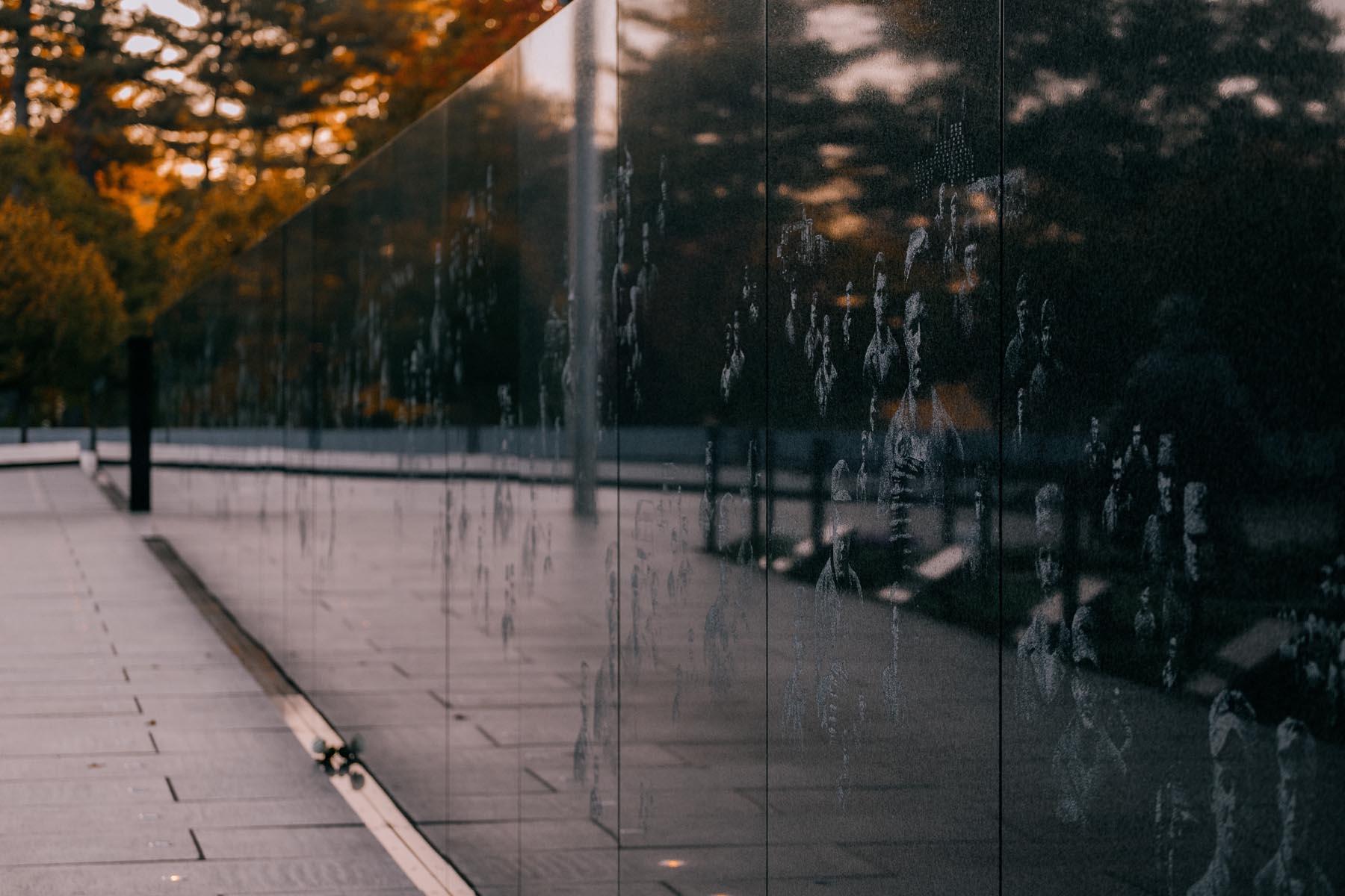 Close-up of the reflective wall at the Korean War Veterans Memorial, engraved with images of soldiers and civilians from the Korean War.
