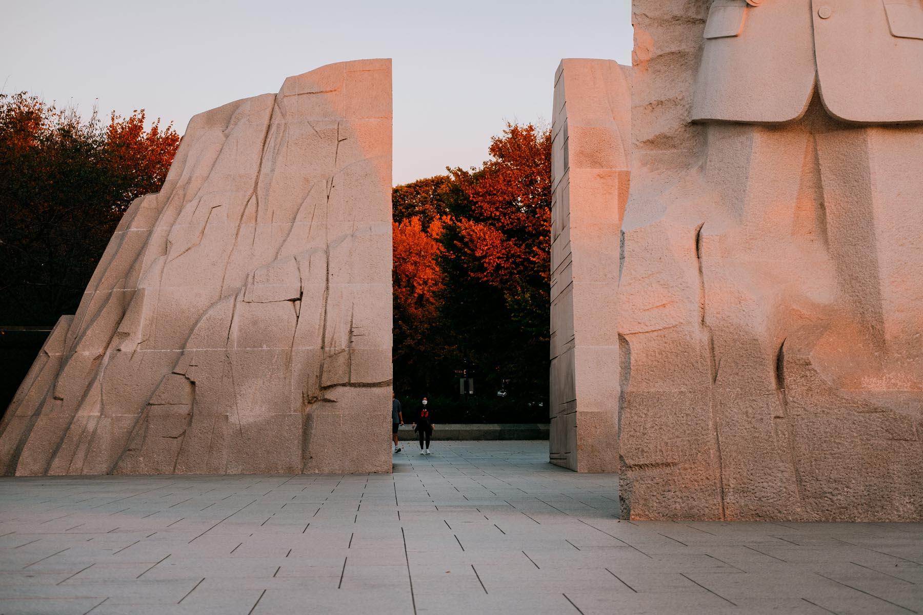 The pathway between the two large stones representing the "Mountain of Despair" at the Martin Luther King Jr. Memorial, leading to the main statue with a backdrop of autumn leaves.